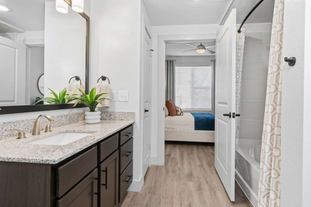 Bathroom with double vanity and modern fixtures at The Heyward Apartments in Corinth, Texas.