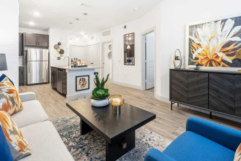 Living room with stylish furniture and accent art at The Heyward Apartments in Corinth, Texas.