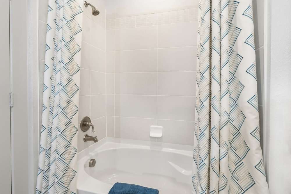 Close-up of bathtub with tile surround at The Heyward Apartments in Corinth, Texas.