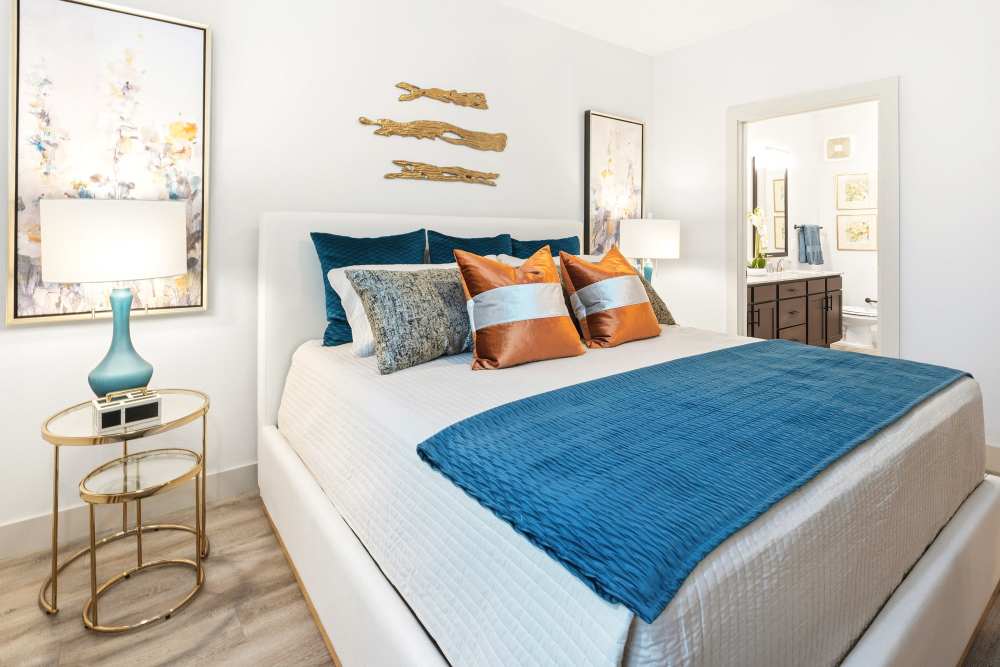 Bedroom with modern decor and en-suite bath at The Heyward Apartments in Corinth, Texas.