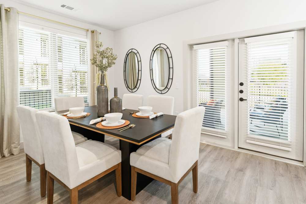 Dining area with glass doors and natural light at The Heyward Apartments in Corinth, Texas.