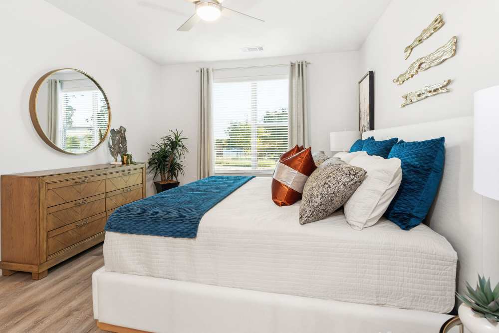 Bedroom with dresser and decorative accents at The Heyward Apartments in Corinth, Texas.