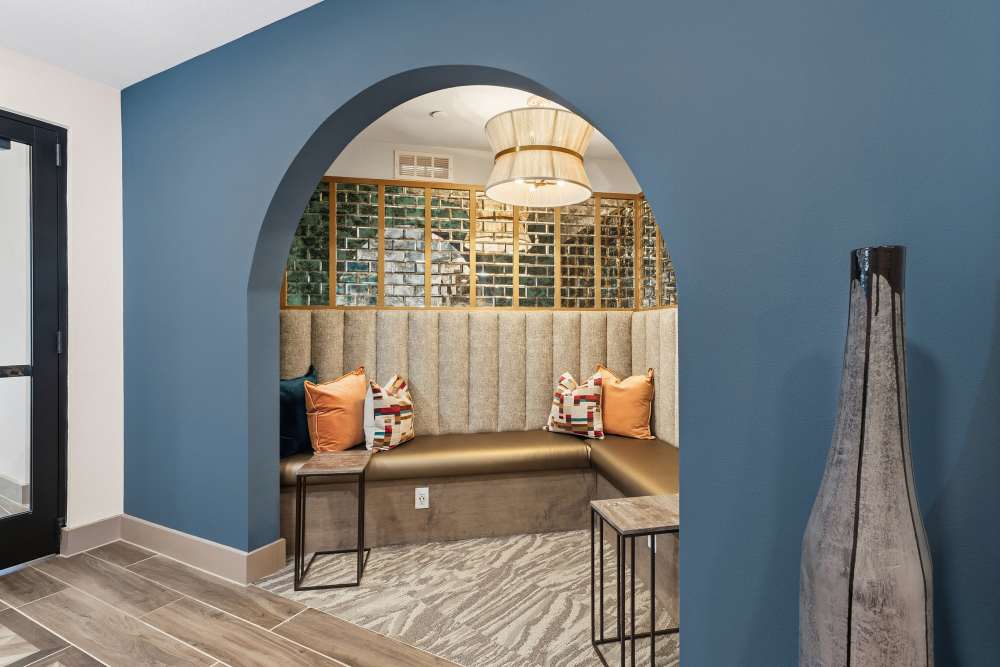 Seating area with archway and mirrored wall at The Heyward Apartments in Corinth, Texas.