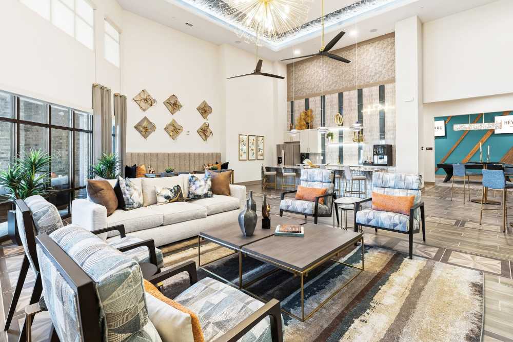 Lounge area with sofa and patterned chairs at The Heyward Apartments in Corinth, Texas.