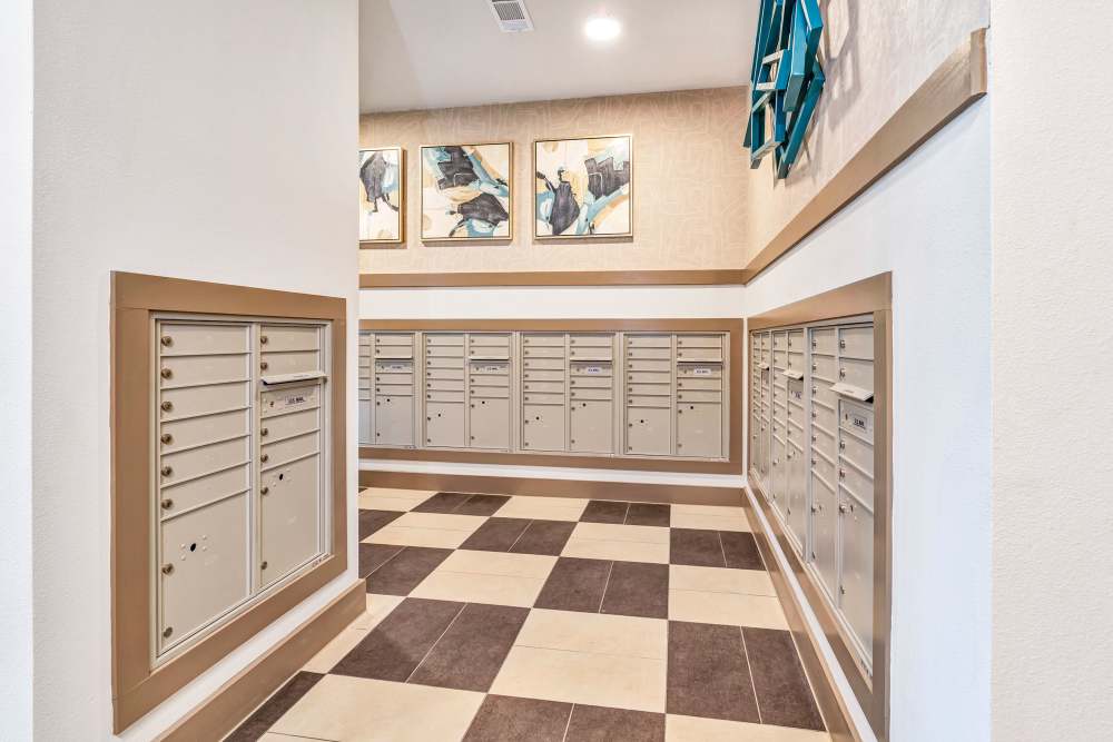 Mailroom with multiple mailboxes and decorative wall art at The Heyward Apartments in Corinth, Texas.