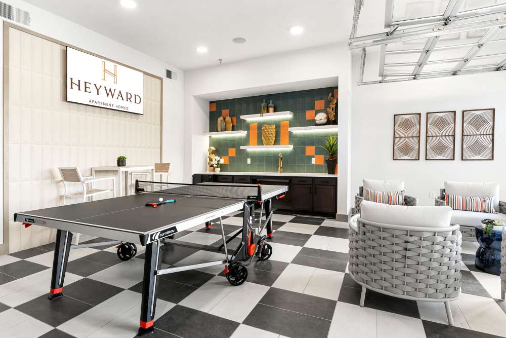 Ping pong table in game room with modern decor at The Heyward Apartments in Corinth, Texas.