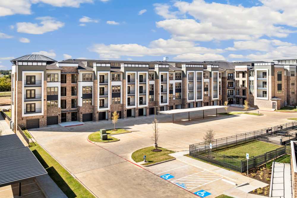 Wide view of apartment complex with multiple buildings at The Heyward Apartments in Corinth, Texas.