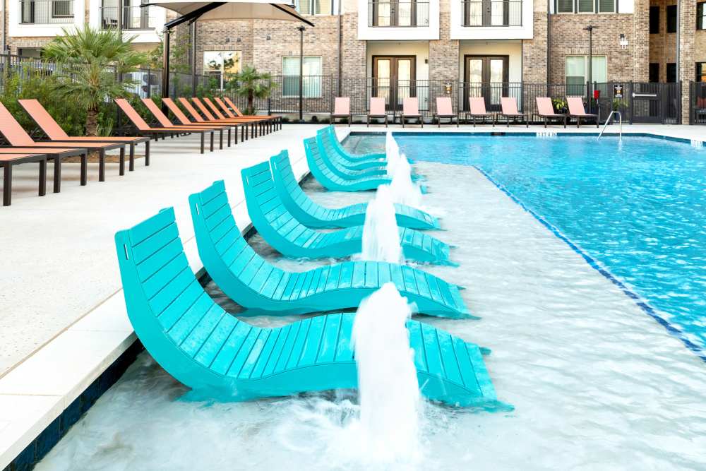 Close-up of in-water loungers with fountains at The Heyward Apartments in Corinth, Texas.
