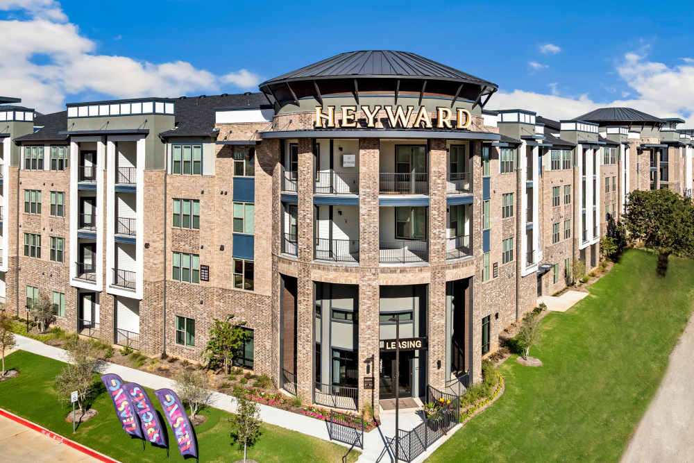 Front view of  The Heyward Apartments building with leasing signage in Corinth, Texas.