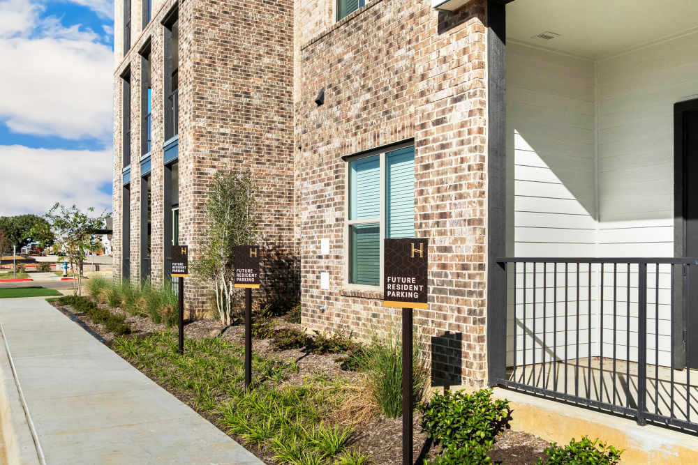 Future resident parking signs near apartment entrance at The Heyward Apartments in Corinth, Texas.