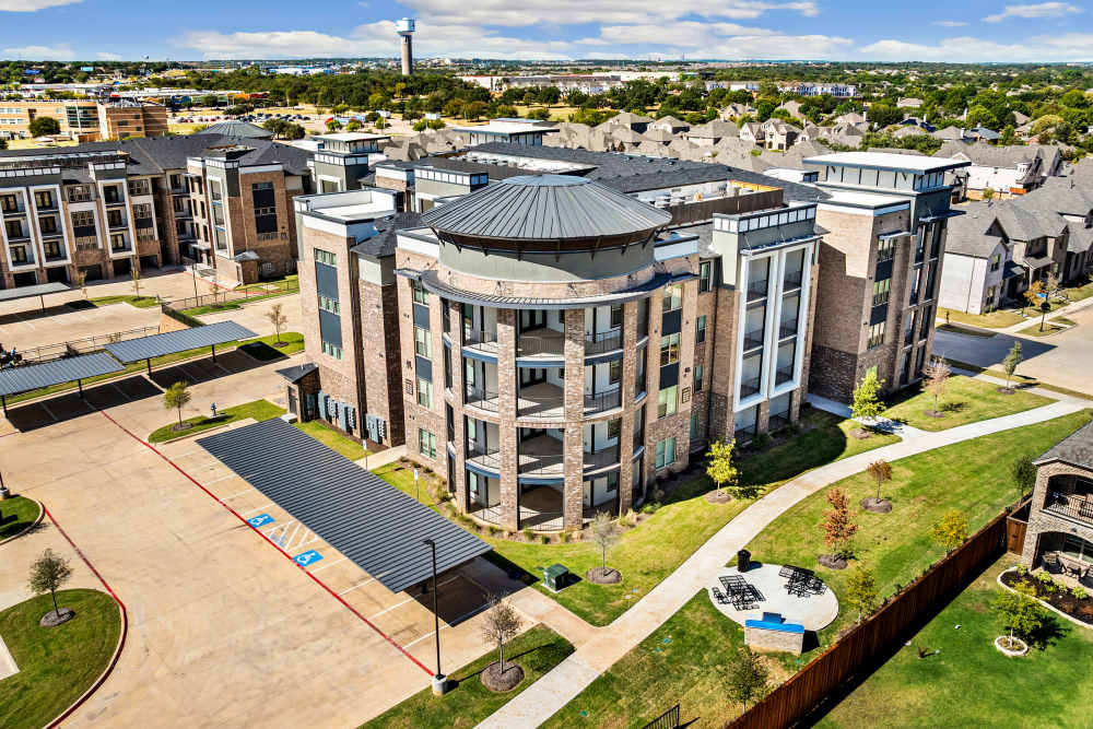 Aerial view of apartment building with landscaped green space at The Heyward Apartments in Corinth, Texas.