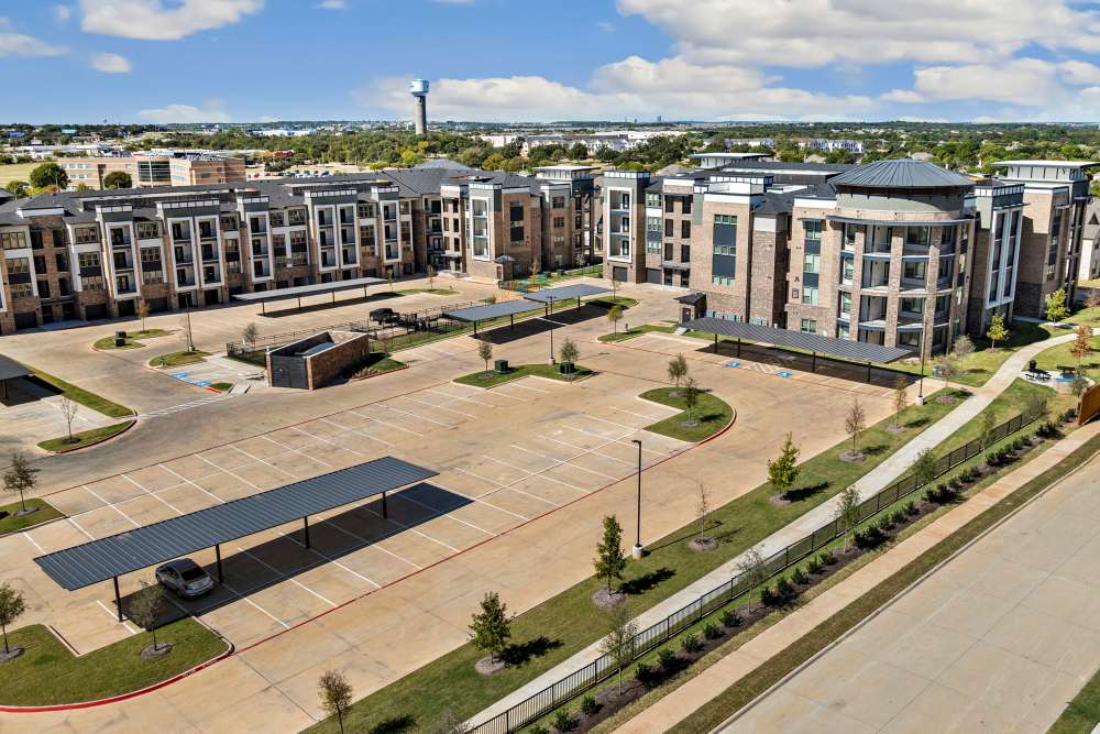 Wide aerial view of apartment complex and parking lots at The Heyward Apartments in Corinth, Texas.