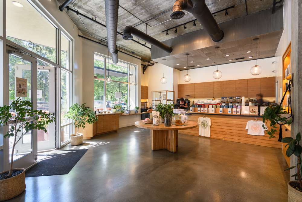 Interior picture of Temple Coffee on 16th Street in Sacramento, CA. Features a large lobby, merchandise for purchase and a coffee order station