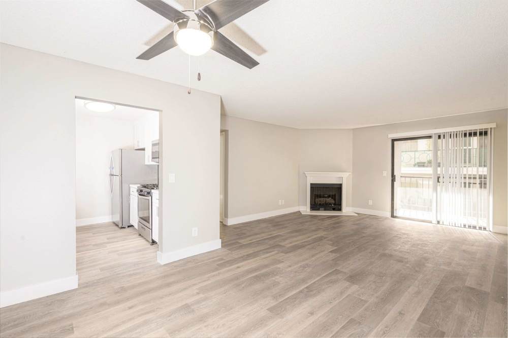 Bright living room with ceiling fan, fireplace, and open kitchen at The Indie Glendale Collection in Glendale, California