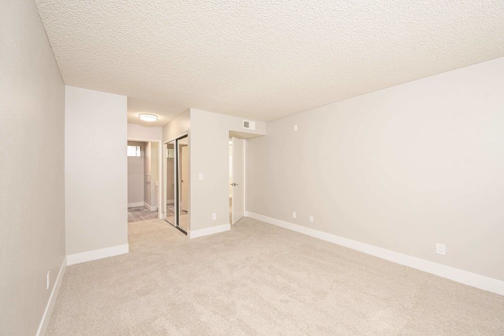 Bedroom with mirrored closet doors and neutral carpet at The Indie Glendale Collection in Glendale, California