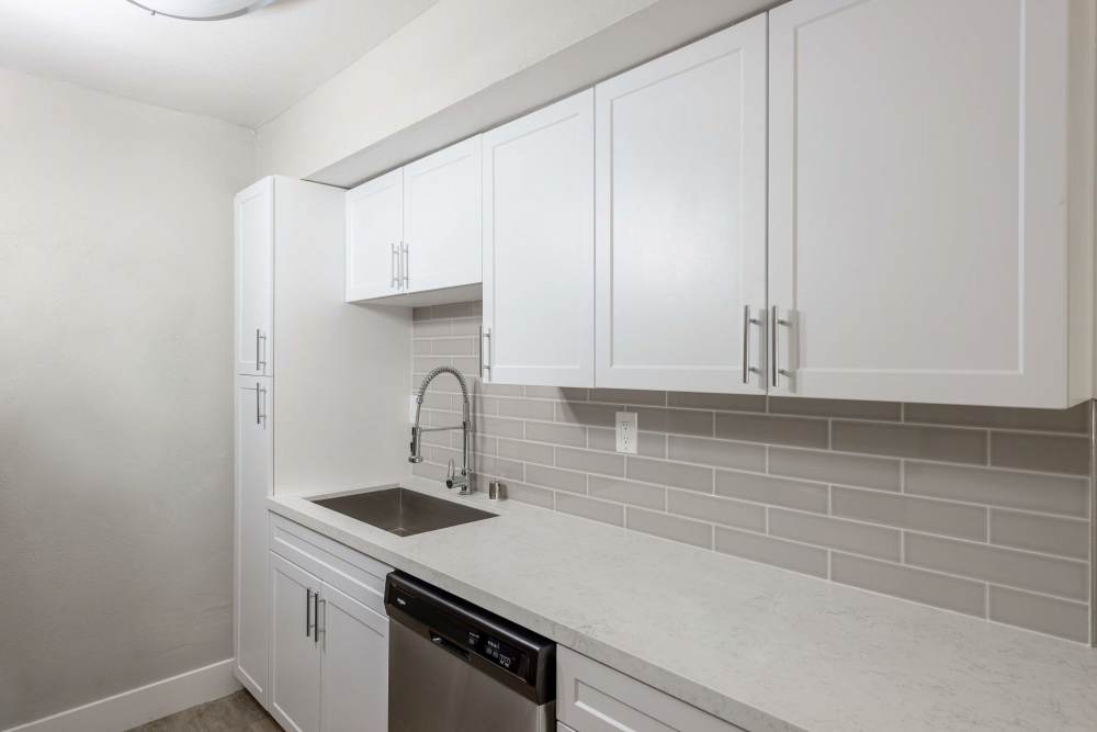 Kitchen with white cabinets and sink at The Indie Glendale Collection in Glendale, California