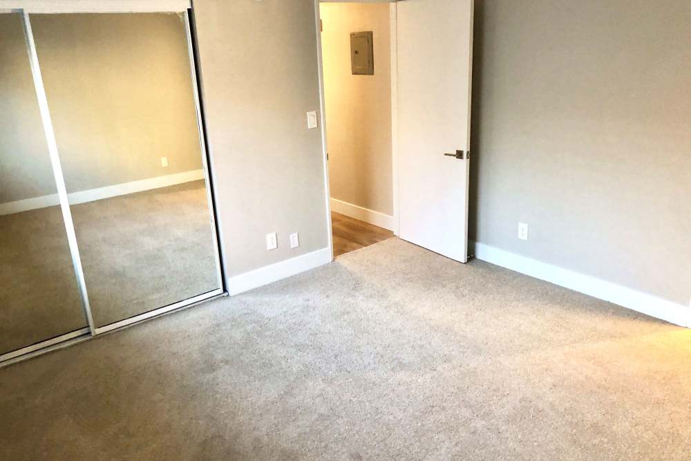Bedroom with carpet flooring and mirrored closet doors at The Indie Glendale Collection in Glendale, California