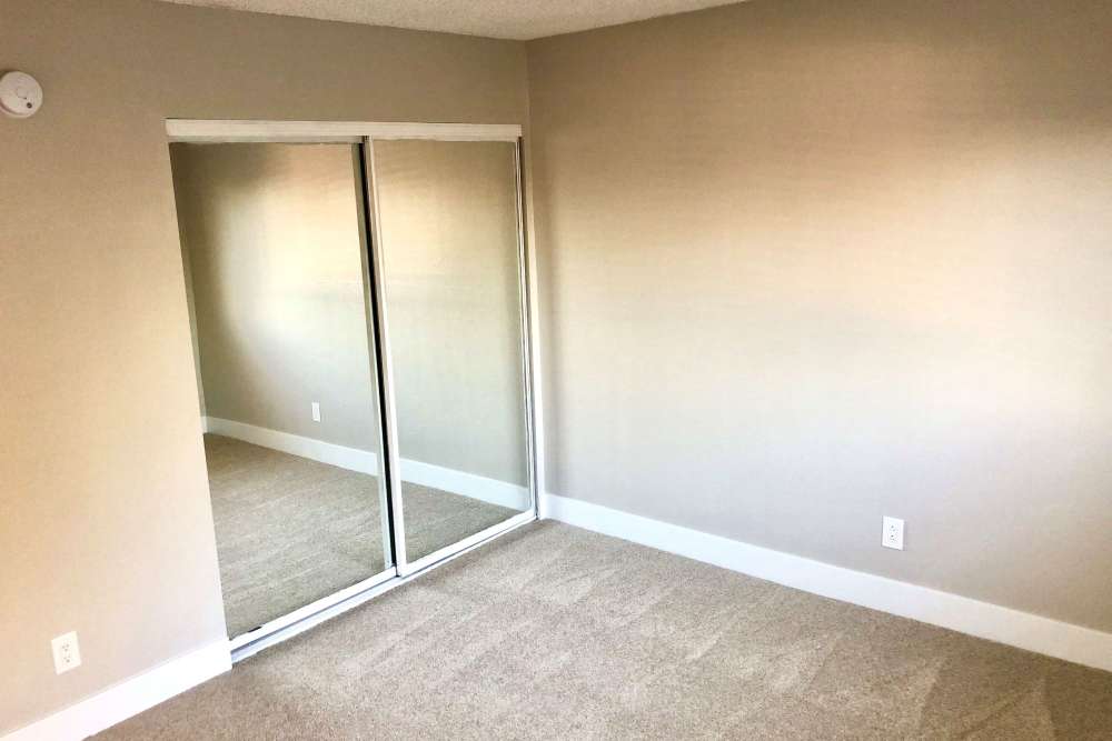 Bedroom with mirrored closet doors at The Indie Glendale Collection in Glendale, California