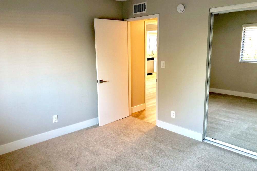 Bedroom with open door and carpet flooring at The Indie Glendale Collection in Glendale, California