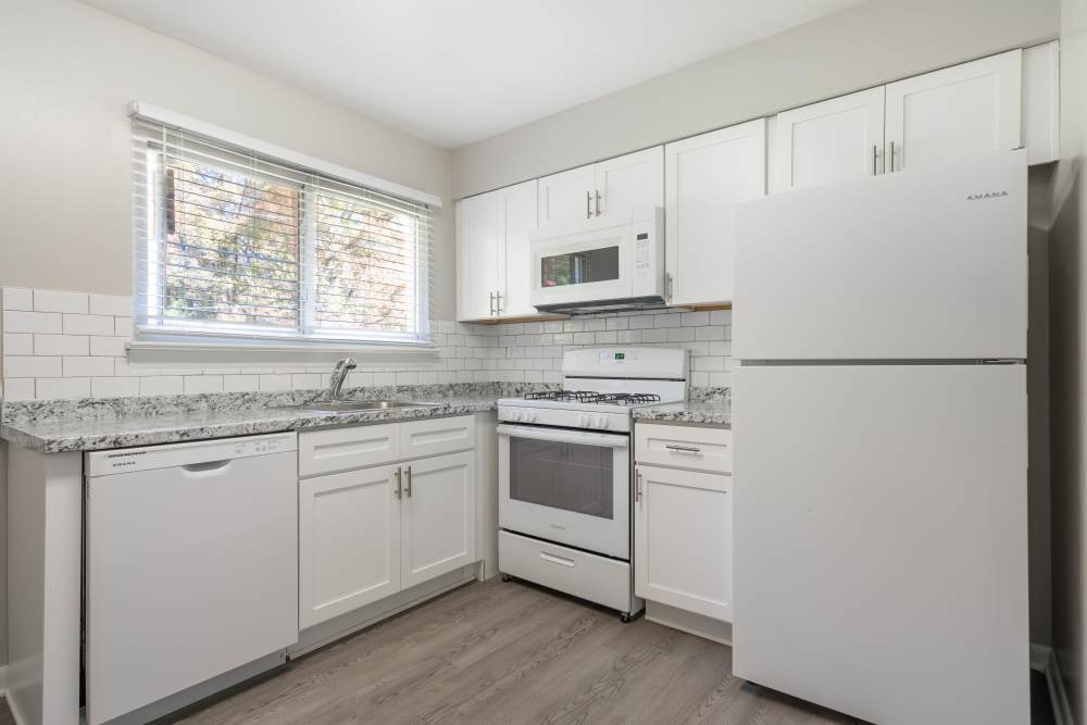 Fully equipped kitchen with white Appliances and wood cabinets at Deering Manor in Richmond, Virginia