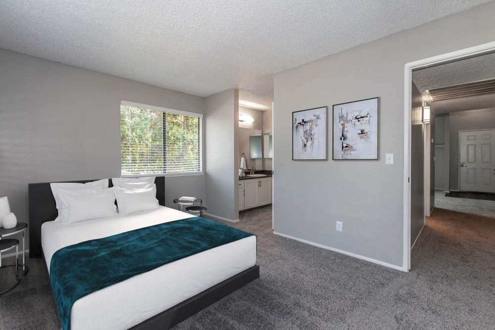 Bedroom with window and attached bathroom at Bennington Apartments in Fairfield, California