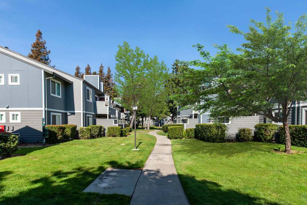 Community exterior building with grass lawn and sidewalk at Bennington Apartments in Fairfield, California