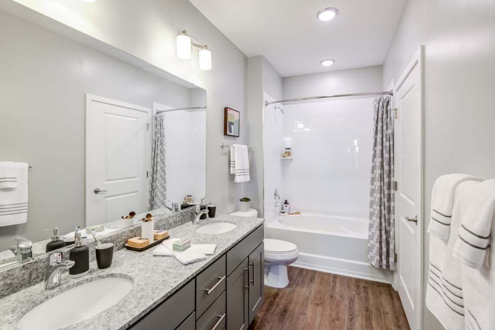dual vanities in bathroom with shower and bath