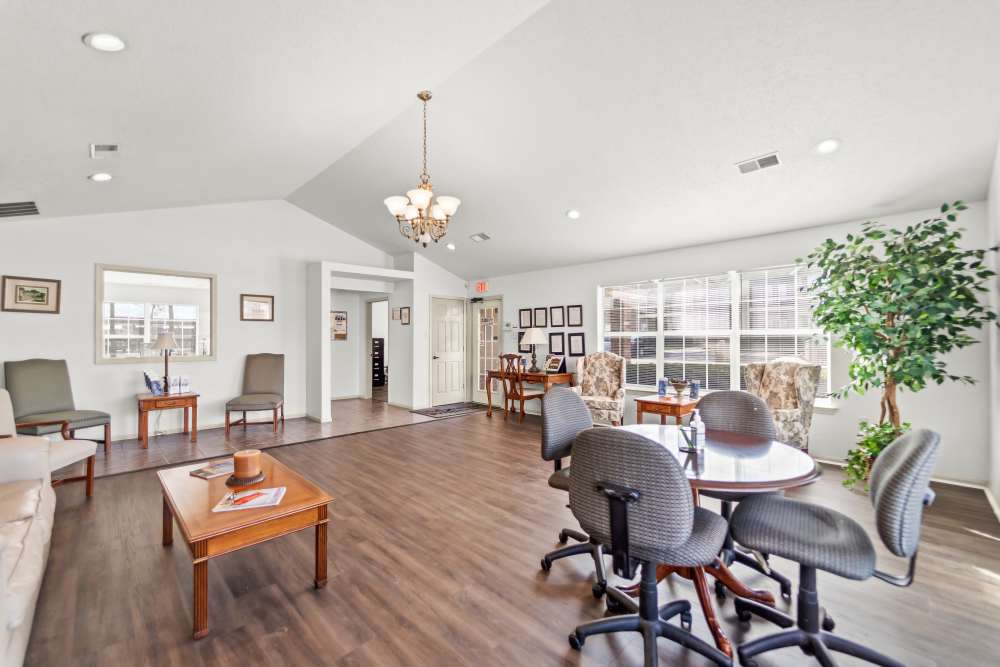 Spacious, well-lit lounge with varied seating, large windows, chandelier at Callaway Village Apartments in Fulton, Missouri