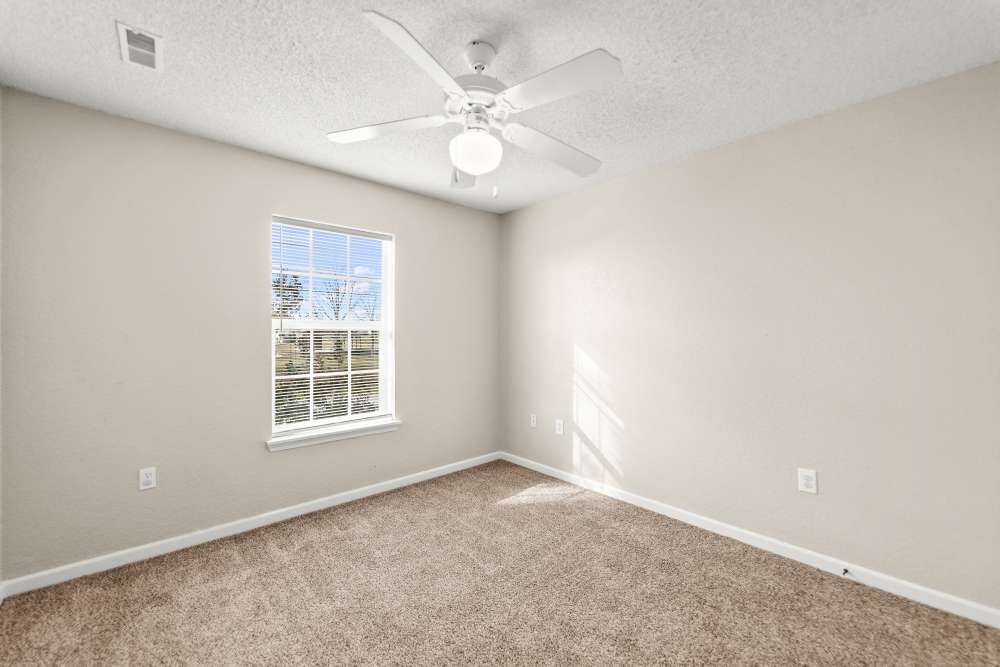 Unfurnished bedroom  with beige carpet, ceiling fan, single window, and natural light at Callaway Village Apartments in Fulton, Missouri
