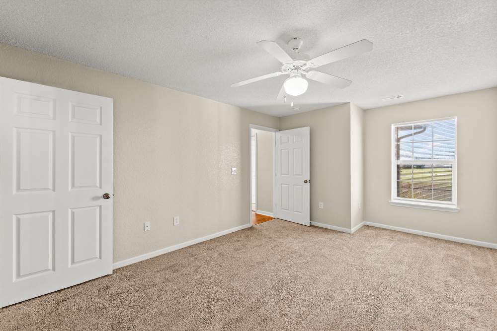 Unfurnished bedroom with ceiling fan and large window at Callaway Village Apartments in Fulton, Missouri