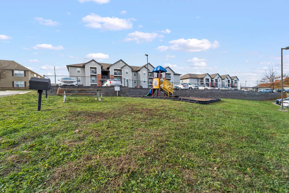 Playground with slide and picnic area in front of apartment buildings at Callaway Village Apartments in Fulton, Missouri