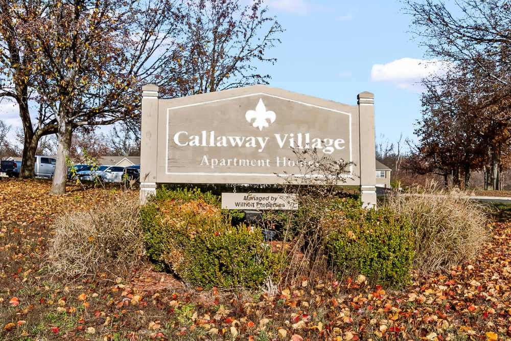 Community signboard surrounded by trees at Callaway Village Apartments in Fulton, Missouri 