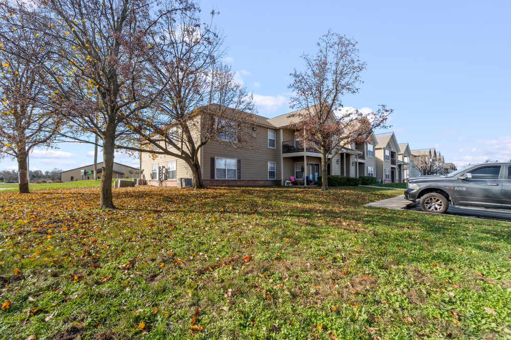 Exterior side view of the apartment surrounded by trees and green lawn at Callaway Village Apartments in Fulton, Missouri