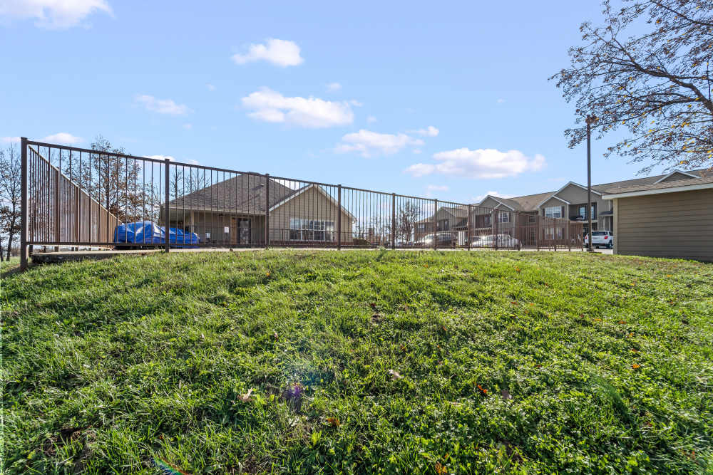 Fenced grassy area with apartment view at Callaway Village Apartments in Fulton, Missouri