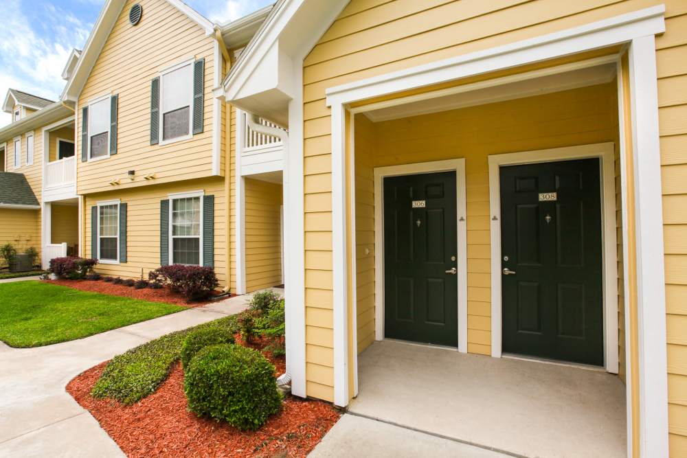 Charming entryway with lush landscaping and inviting double doors at Country Lane in Angleton, Texas