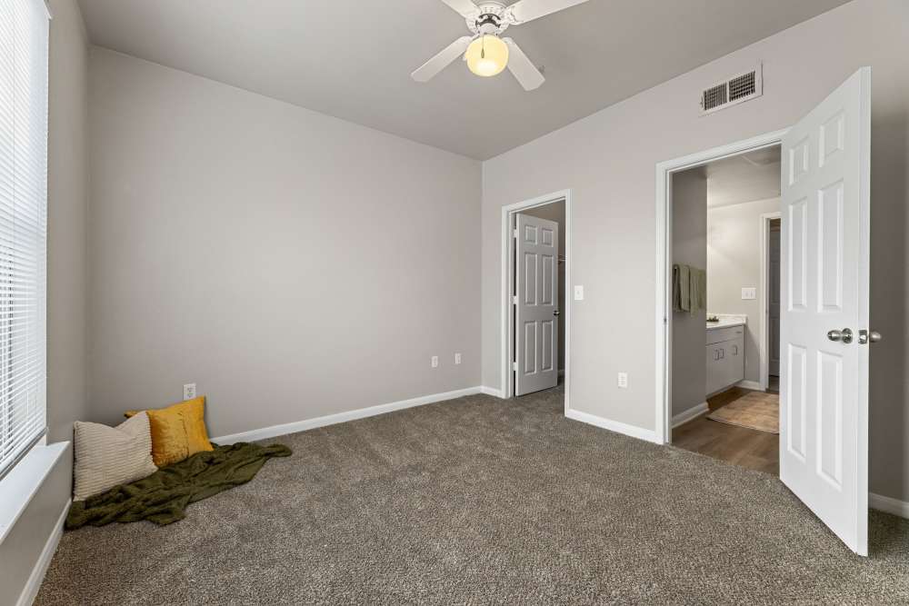 Bedroom with carpet flooring and attached bathroom, closet at Columbia Greens in Houston, Texas