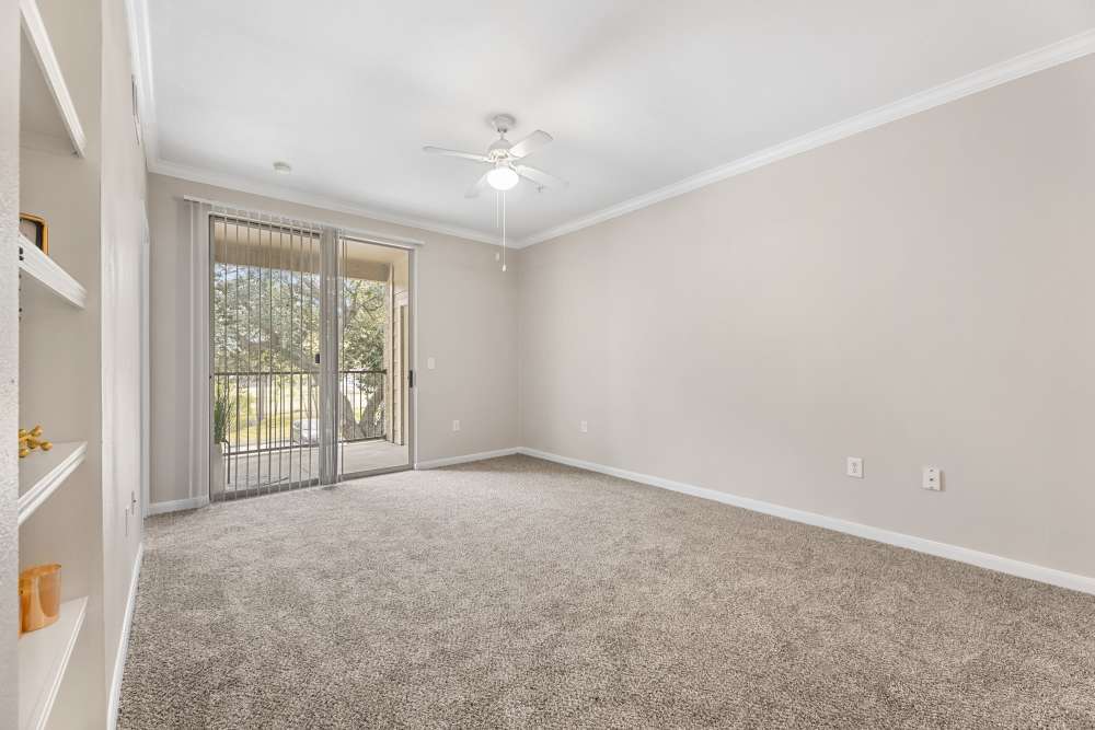 Living area with carpet flooring and patio sliding glass door view at Columbia Greens in Houston, Texas
