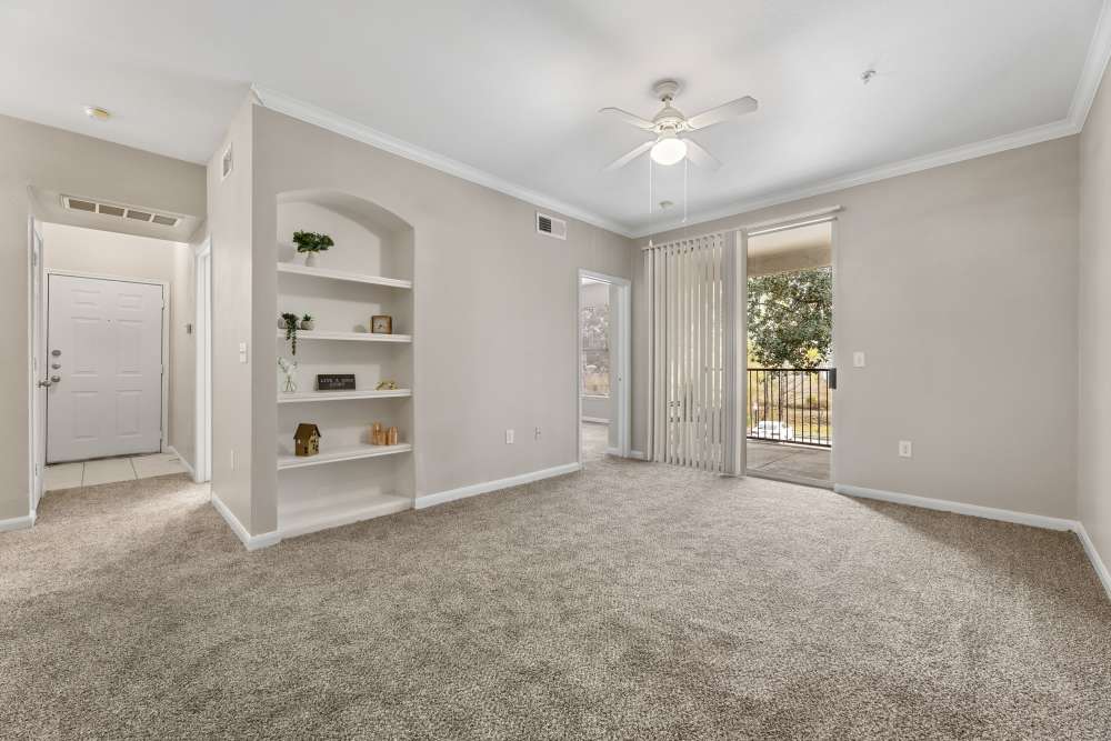 Living area with carpet flooring, niche shelf  and patio sliding glass door view at Columbia Greens in Houston, Texas
