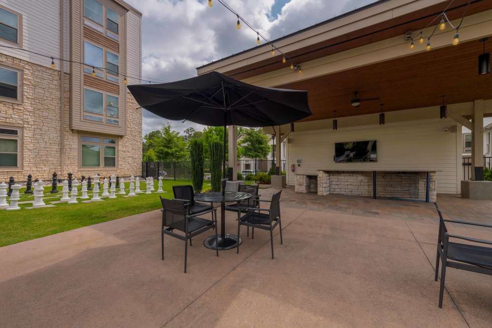 outdoor lounge area with tables chairs and tv The Reserve at Patterson Place durham NC luxury apartments