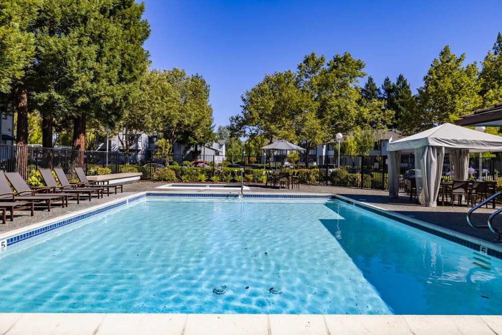 Large swimming pool with lounge chair at Country Brook Rental Condominiums in San Ramon, California
