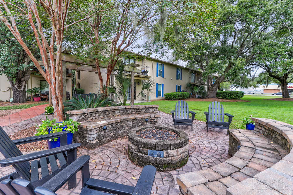 Stone fire pit surrounded by wooden chairs at Spanish Oaks in Charleston, South Carolina