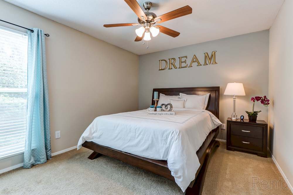 Cozy bedroom with queen bed and ceiling fan at Spanish Oaks in Charleston, South Carolina