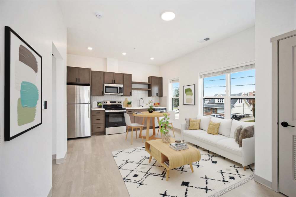 Bedroom with sliding closet doors and barn door opening to kitchen, light wood flooring at Terra Station, Hudsonville, Michigan