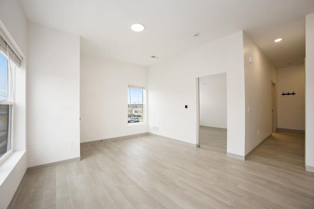 Spacious living area with light wood flooring, large windows, and open layout at Terra Station, Hudsonville, Michigan