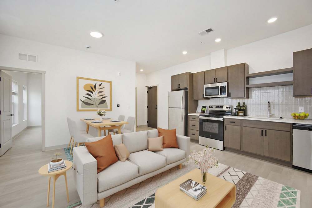 Stylish kitchen and living area with stainless steel appliances, cozy sofa, and dining table at Terra Station, Hudsonville, Michigan