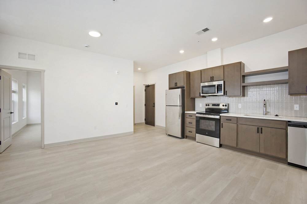 Contemporary kitchen with stainless steel appliances, wood cabinets, and light flooring at Terra Station, Hudsonville, Michigan