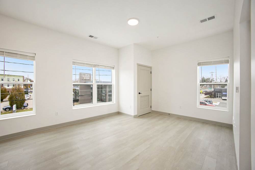 Bright bedroom with large windows, neutral flooring, and closet door offering natural light at Terra Station, Hudsonville, Michigan