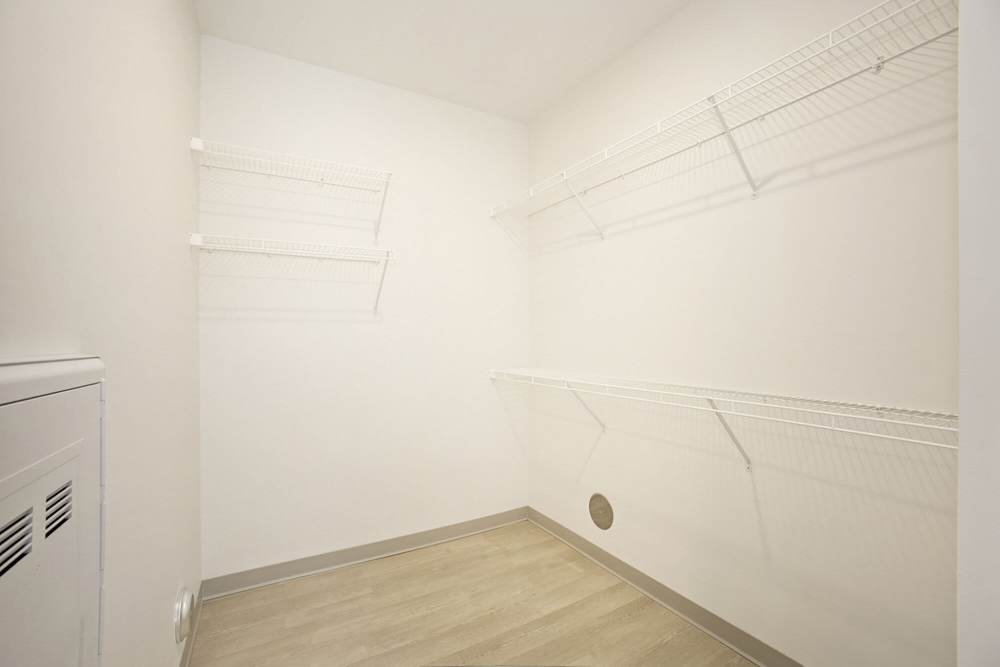 Walk-in closet with white wire shelving and light wood flooring for ample storage space at Terra Station, Hudsonville, Michigan
