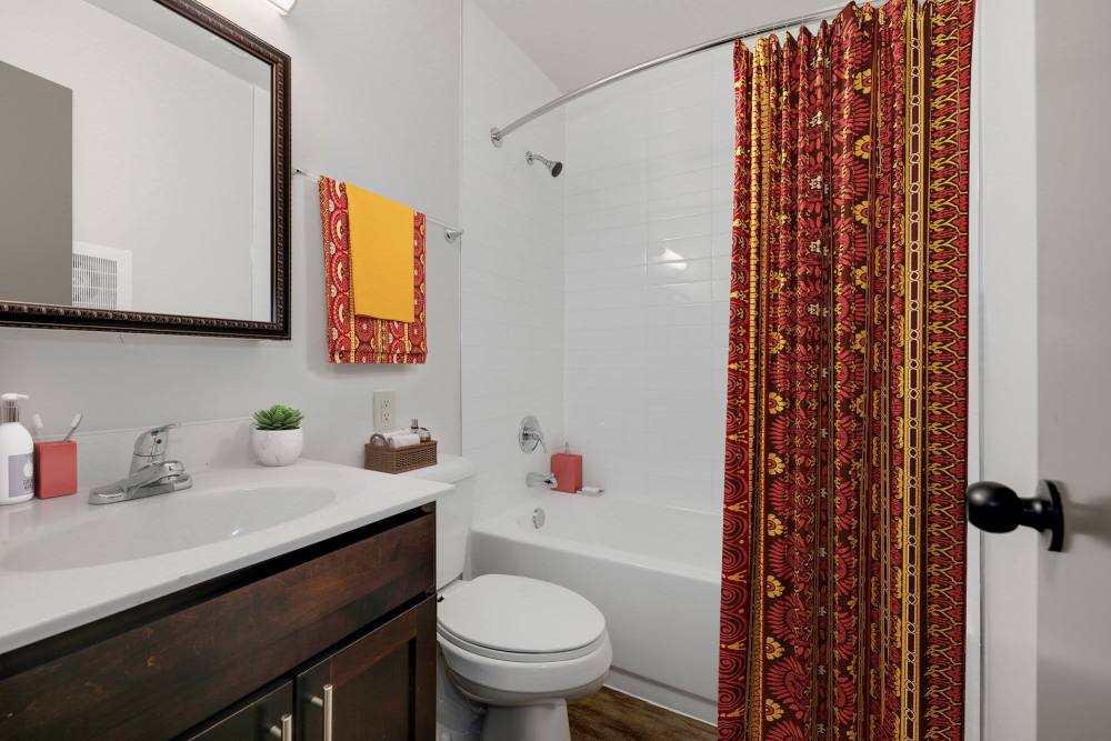 Brightly colored bathroom with modern fixtures and stylish shower curtain at Parkside Landing Apartments in Rockville, Maryland