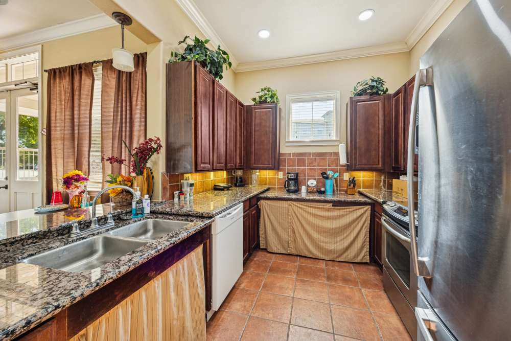 Upgraded kitchen with granite countertops and modern appliances kitchen in the clubhouse at Gibraltar Senior in Clute, Texas
